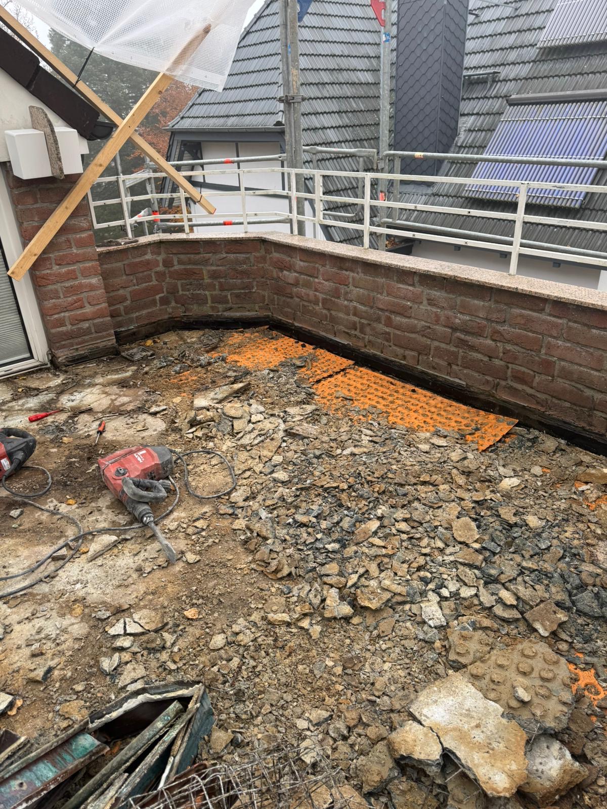 Aktiver Balkon- und Terrassenrückbau mit Werkzeugen und freilegtem Untergrund